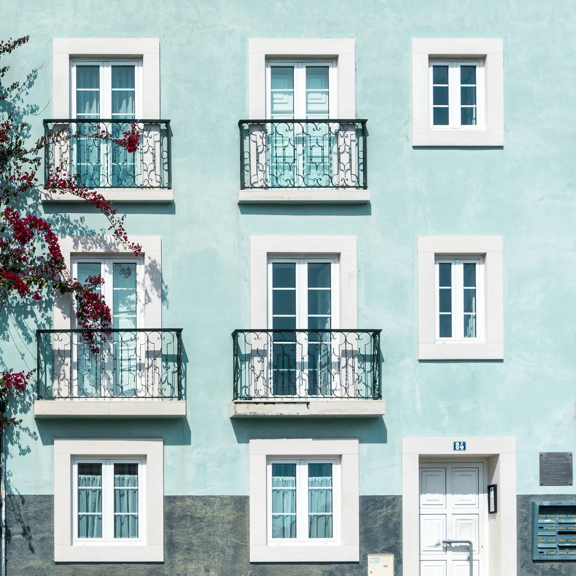 Pastel-blue apartment building with wrought-iron balconies in Lisbon